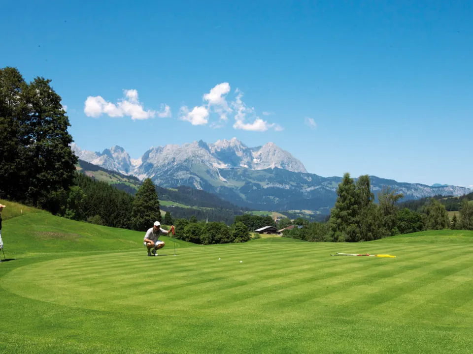 Zwei Golfer auf dem Grün, im Hintergrund der Wilde Kaiser